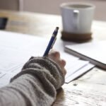 Na foto: pessoa com caderno fazendo anotações